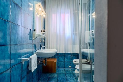 a blue bathroom with two toilets and a sink at Villa Lucia in Caorle