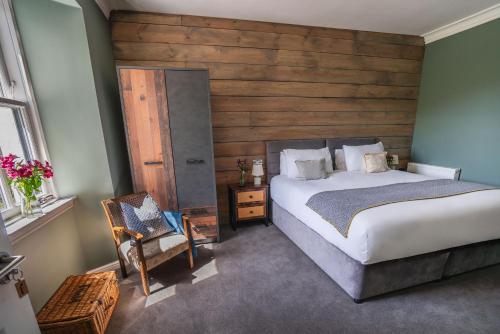 a bedroom with a large bed and a chair at The Kilchrenan Inn in Oban