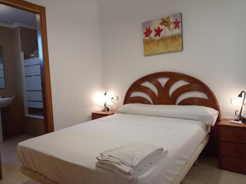 a bedroom with a large bed with a wooden headboard at Parquemar VIII Solo Familias Serviplaya in Playa de Xeraco
