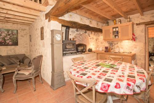 a kitchen and dining room with a table and a stove at GITE FOUR A PAIN 4 pers in Bon-Encontre