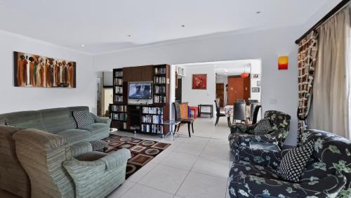 a living room with a couch and two chairs at Konrad 8 in Uvongo Beach
