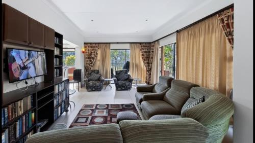a living room with a couch and a tv at Konrad 8 in Uvongo Beach