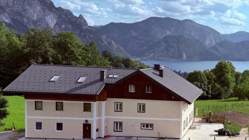 a house with a red roof with mountains in the background at Attersee Panorama Apartments in Steinbach am Attersee