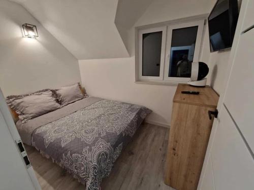 a small bedroom with a bed and a window at Apartament Konecka 2J in Sielpia Wielka