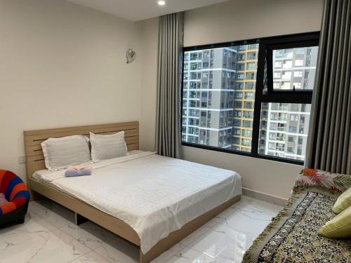 a bedroom with a bed and a large window at Anna Vinhomes Grand Park in Ho Chi Minh City
