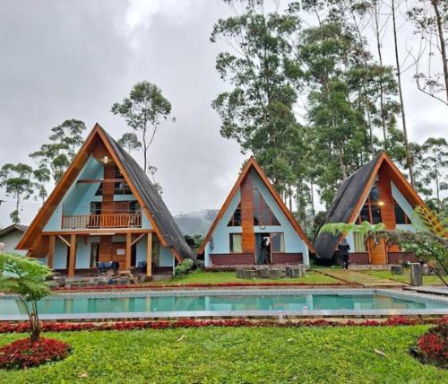 a house with a thatched roof and a pool at Cozzy Artana Cabin in Palayangan
