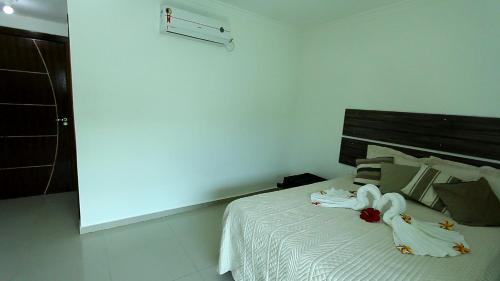 a bedroom with a bed with two swans on it at Hotel Pousada Oasis in Conde