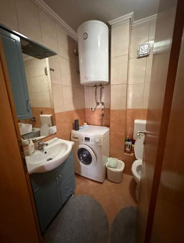 a small bathroom with a washing machine and a sink at Apartman Bugojno in Bugojno