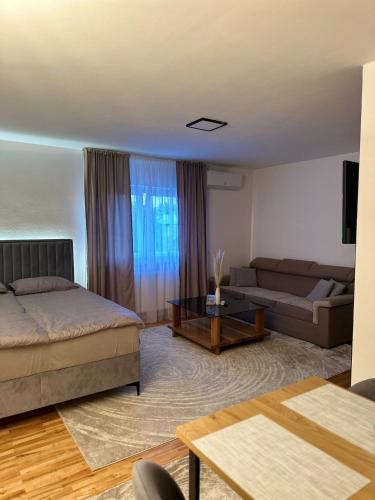 a living room with a bed and a couch at Apartman Bugojno in Bugojno