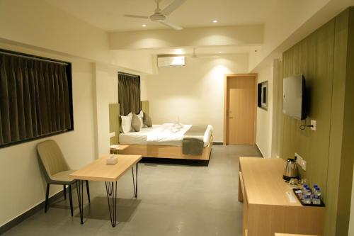 a hotel room with a bed and a table at Hotel The Nature Regency in Satara