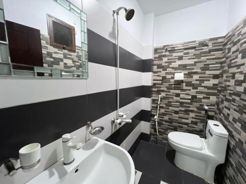 a bathroom with a white toilet and a sink at Karachi Inn in Karachi