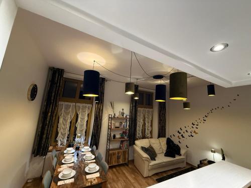 a living room with a table and a couch at Central Golden Apartment in Nowy Sącz
