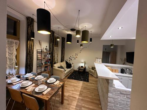 a dining room and living room with a table at Central Golden Apartment in Nowy Sącz