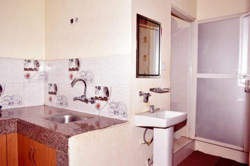 a bathroom with a sink and a toilet and a mirror at Kattel Homestay and Apartments in Bālāju