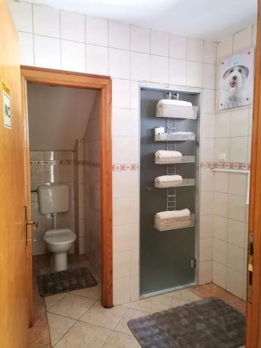 a bathroom with a toilet and a dog on the wall at Apartman Nik-Rom 1 in Bosanska Gradiška