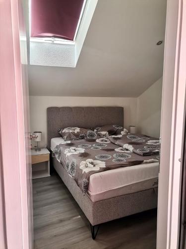 a bed in a small room with a window at Apartman Nik-Rom 1 in Bosanska Gradiška