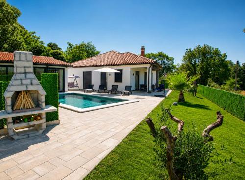 a backyard with a swimming pool and a house at Villa Riviera in Nedeščina