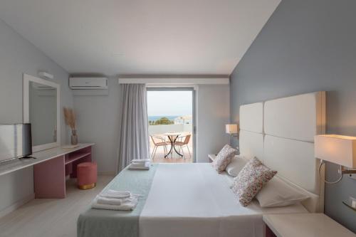 a hotel room with a bed and a balcony at Sunrise Village Hotel - All Inclusive in Platanias