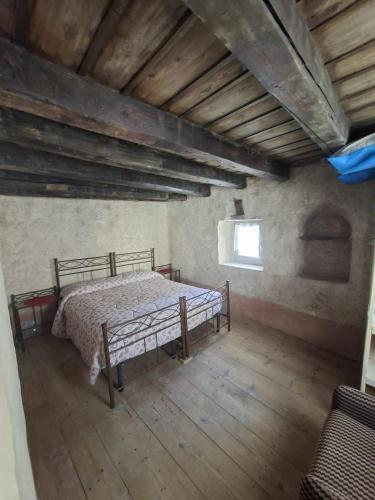 a bedroom with a bed in a room with wooden floors at ALBERGO DIFFUSO ORNICA NEL CUORE in Ornica