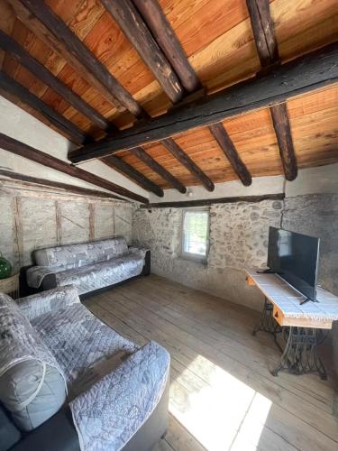 a room with a couch and a desk with a television at ALBERGO DIFFUSO ORNICA NEL CUORE in Ornica