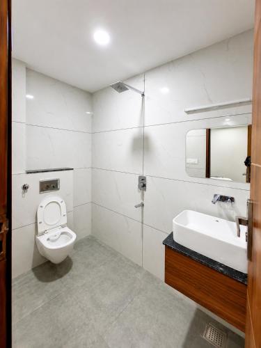 a white bathroom with a toilet and a sink at hotel glory in Haridwār