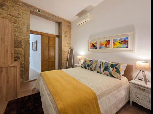 a bedroom with a bed with a yellow blanket at Monção Golden I in Monção