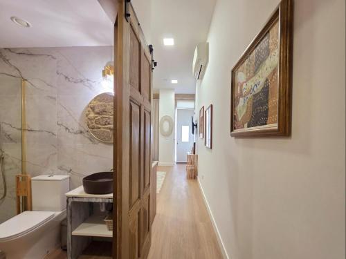 a bathroom with a wooden door and a sink at Monção Golden I in Monção