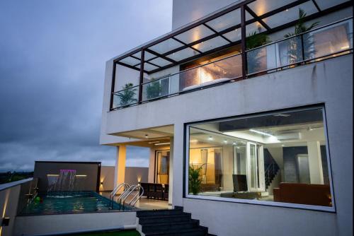 a house with a swimming pool and a balcony at Evara Sky Jacuzzi Villa in Igatpuri