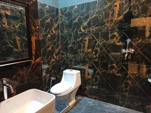 a bathroom with a white toilet and a sink at Green hillock hotel in Alwar