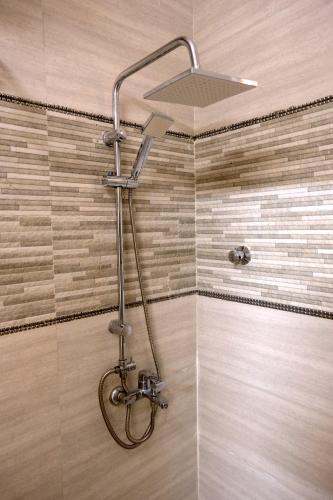 a shower with a shower head in a bathroom at Sea Turtles Guest House in Al Ḩadd