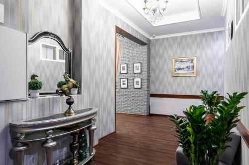 a hallway with a mirror and a sink in a room at Rush Inn Hotel in Astana