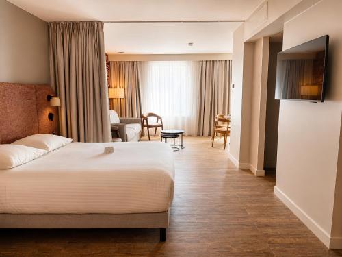pokój hotelowy z łóżkiem i salonem w obiekcie L'Ours de Mutzig - Hôtel Restaurant & Spa w mieście Mutzig