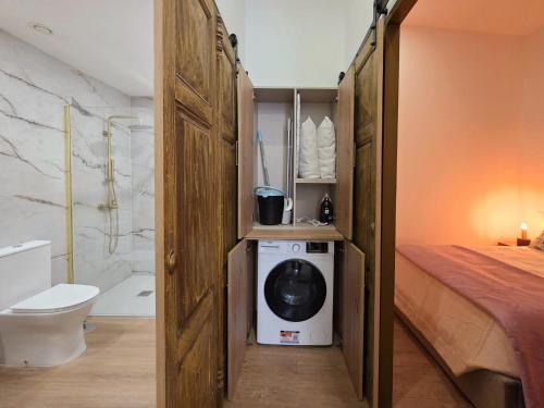 a bathroom with a bed and a washing machine in a room at Monção Golden I I in Monção