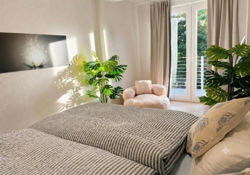 a bedroom with a bed and a chair and a window at EDA di Lago, 2-Zimmer Wohnung, Kostenfreies Parken, 24h Check-IN in Reichenau