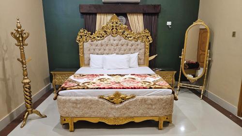 a bedroom with an ornate bed with a gold frame at Hotel Destination in Sukkur