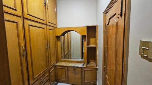a bathroom with wooden cabinets and a mirror at Hotel Destination in Sukkur