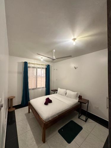 a bedroom with a bed and a ceiling fan at Diani Beach Modern Apartment in Diani Beach