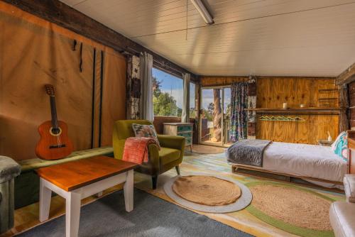 a bedroom with a bed and a guitar in a room at SilverSprings Spa Retreat Pet Friendly Cottages and Glampings in Metricup