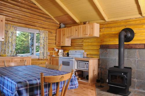 a kitchen with a table and a stove in a cabin at Domaine Annie Sur Mer in Metis Beach