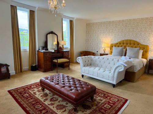 a bedroom with a bed and a couch and a mirror at Grant Arms Hotel in Grantown on Spey