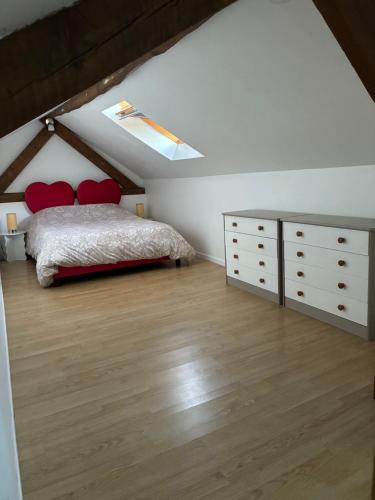 a attic bedroom with a bed and a dresser at Maisonnette in Chambon-sur-Voueize