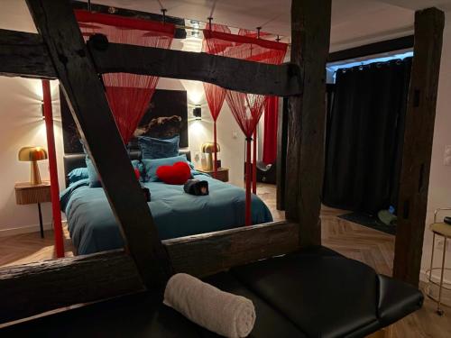 a bedroom with a large wooden bed with blue sheets at Le fruit défendu 67 in Brumath