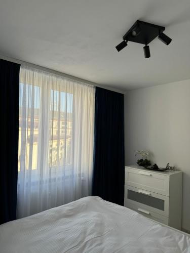 a bedroom with a white bed and a window at Ultracentral style apartment! in Craiova