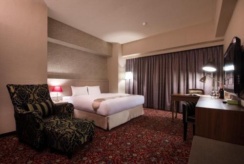 a hotel room with a bed and a chair and a desk at Hu House in Kaohsiung