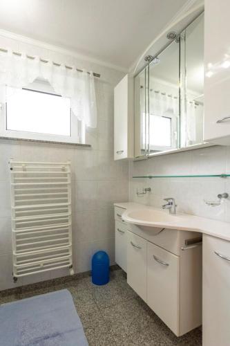 a white bathroom with a sink and a mirror at Dom przy plaży in Giewartów