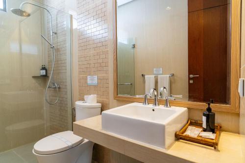 a bathroom with a sink and a toilet and a mirror at Oyama City View Villa 4 Bedrooms With a Private Heated Swimming Pool and a Billiard Table in Bandung