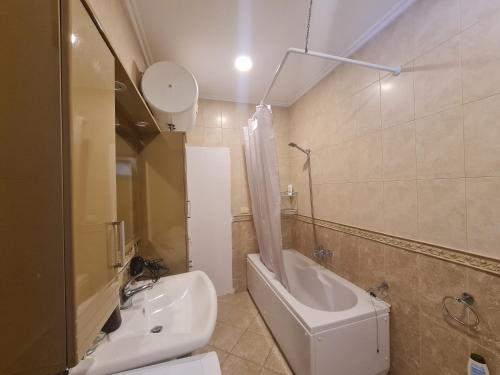 a bathroom with a toilet and a tub and a sink at Hotel La Cita in Tirana