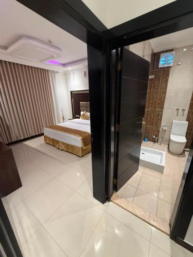 a bedroom with a bed and a shower and a bathroom at Grand Seasons Serviced Apartments dammam جراند سيزون للشقق المخدومة الدمام in Dammam