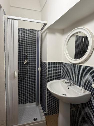 a bathroom with a sink and a shower with a mirror at Dimora Via Roma in San Severo
