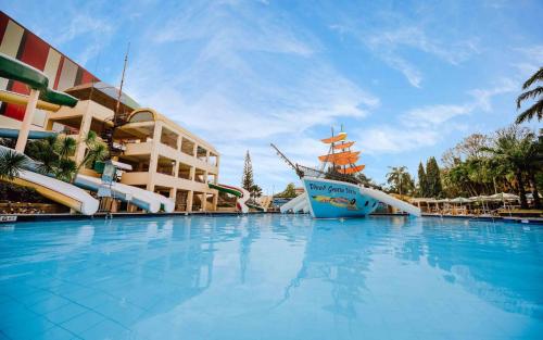 a large swimming pool with a cruise ship in front of a building at Grotto Vista Resort in San Jose del Monte